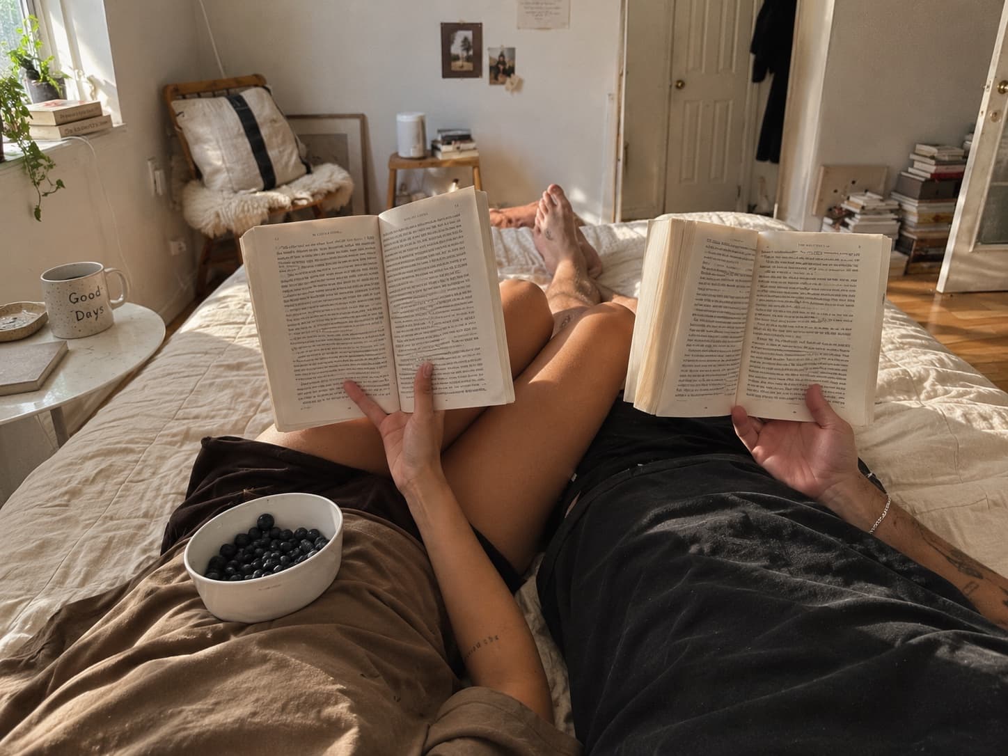 Two people lying on a bed, each reading their own book